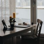 A serene indoor workspace is adorned with candles and a view of the city through a window.
