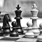 Monochrome photo of chess pieces poised for a strategic game.